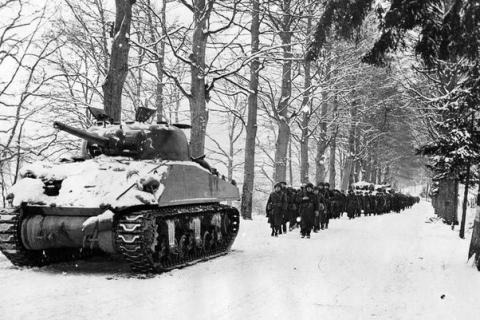 Historic image of tanks and soldiers during the Battle of the Bulge in WWII. 