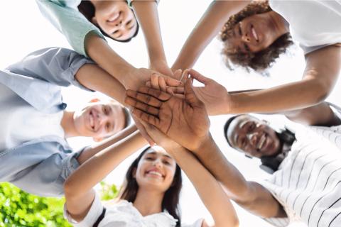 teens in a circle with hands in center