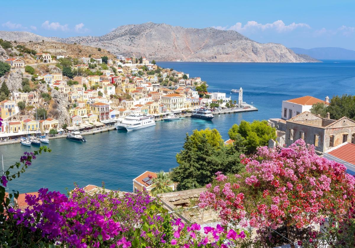 A photo of a Greek town on the coast with spring flowers.